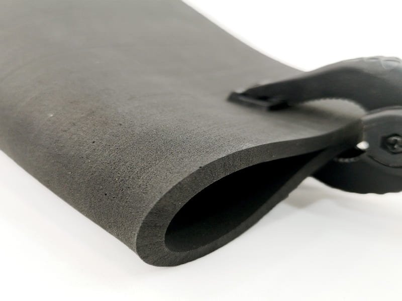 Close-up view of a durometer measuring the hardness of a rubber gym floor tile